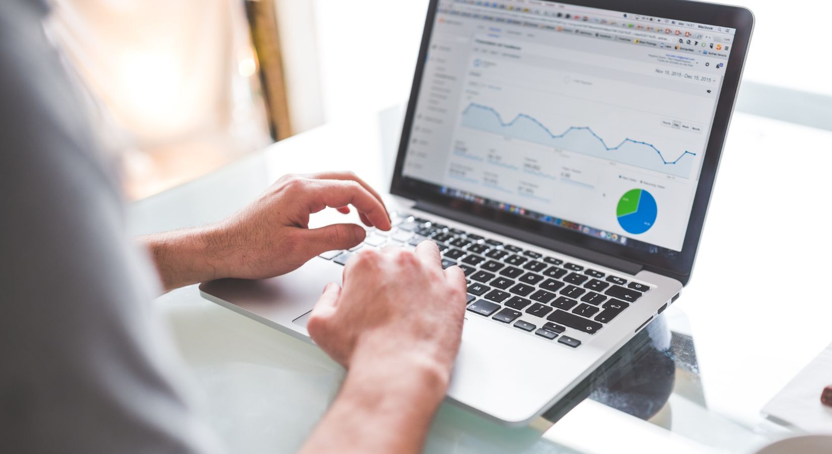 person analyzing website traffic data on a laptop with charts and graphs displayed