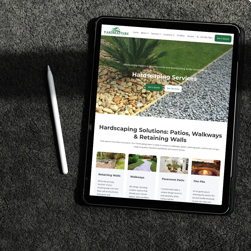 tablet displaying yardmasters hardscaping services webpage on a dark textured surface